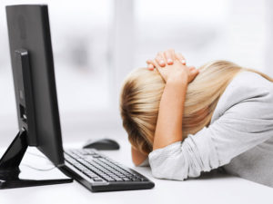 Lady with her head on her desk, frustrated over computer issues she may be having in Anchorage, Alaska